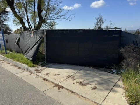 Altadena construction site with privacy fence along sidewalk showing pre-construction grade for drainage plan
