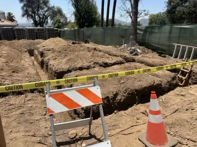 Concrete forming in progress for retaining wall with visible rebar reinforcement and black drainage pipe being installed through hillside slope on Altadena fire rebuild site