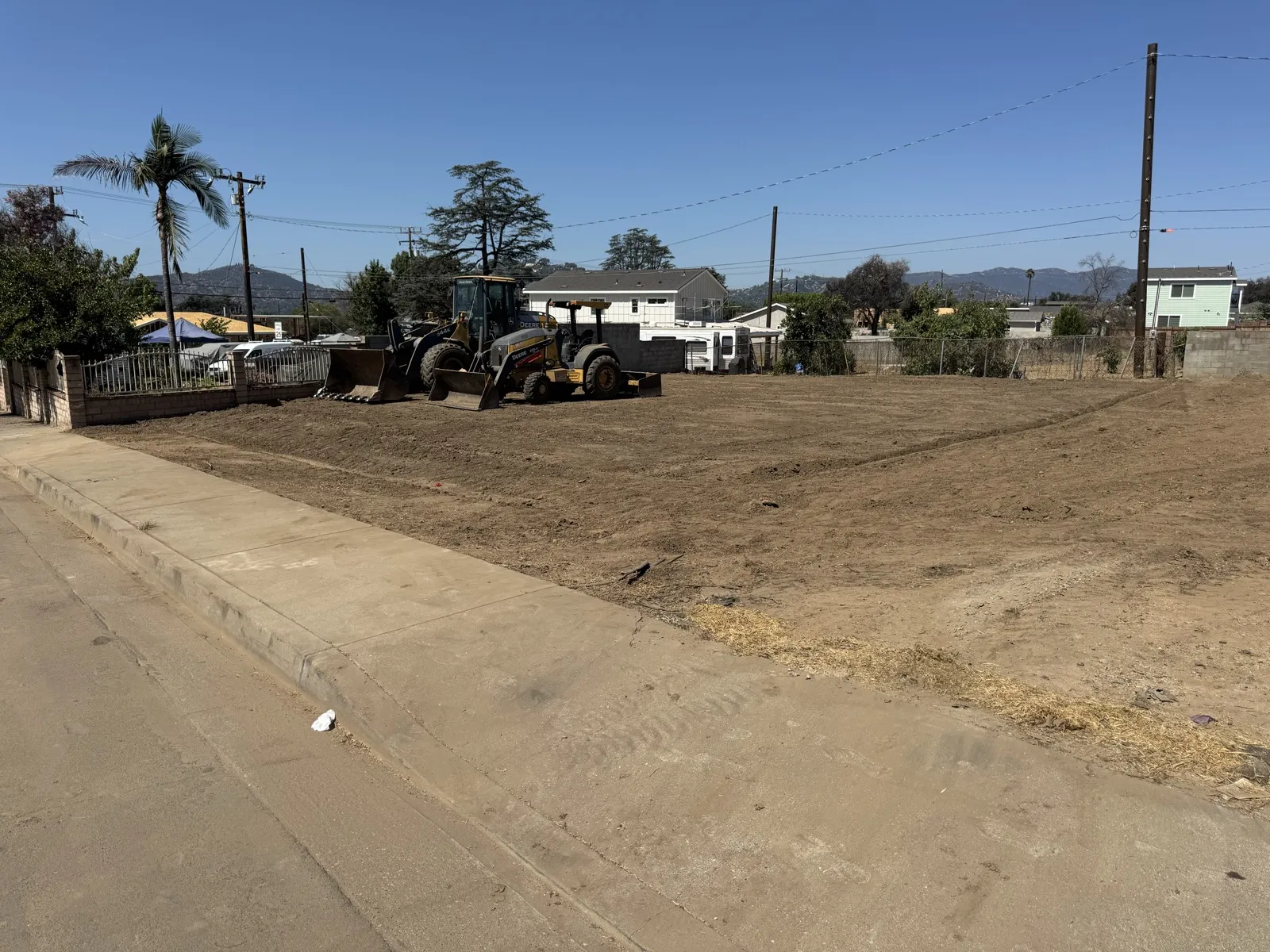 Rough grading at the Glenrose Avenue Altadena fire rebuild lot with a Deere wheel loader and motor grader shaping the pad and flowlines