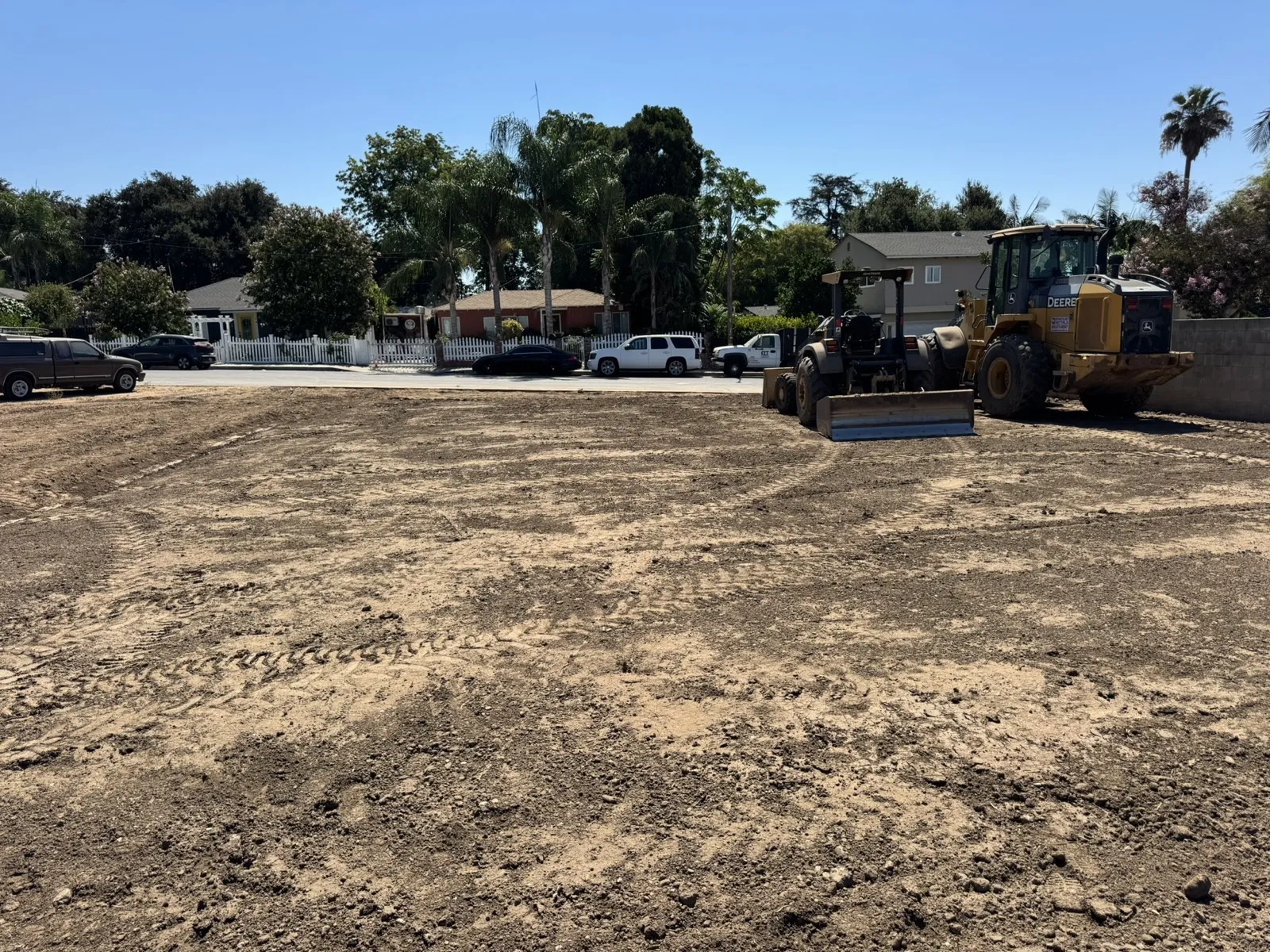 Soil compaction at the Glenrose Avenue Altadena fire rebuild lot with a Caterpillar sheepsfoot roller and Deere motor grader finishing the pad