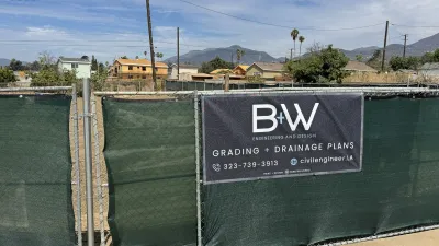 B+W Engineering Grading + Drainage Plans job-site banner on the chain-link fence at the Glenrose Avenue Altadena fire rebuild lot, with rough-graded dirt and the San Gabriel Mountains behind