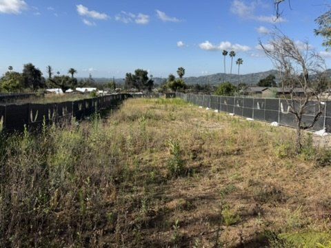 Altadena lot enclosed by construction fence featuring terrain for our drainage plan engineering