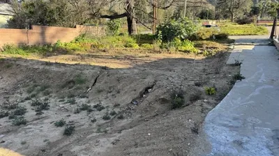 Altadena post-fire eroded terrain with concrete walkway showing drainage assessment