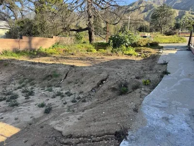 Altadena post-fire eroded terrain with concrete walkway showing drainage assessment