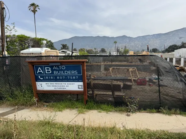 Pre-construction Altadena fire rebuild lot with Alto Builders sign and mountain views