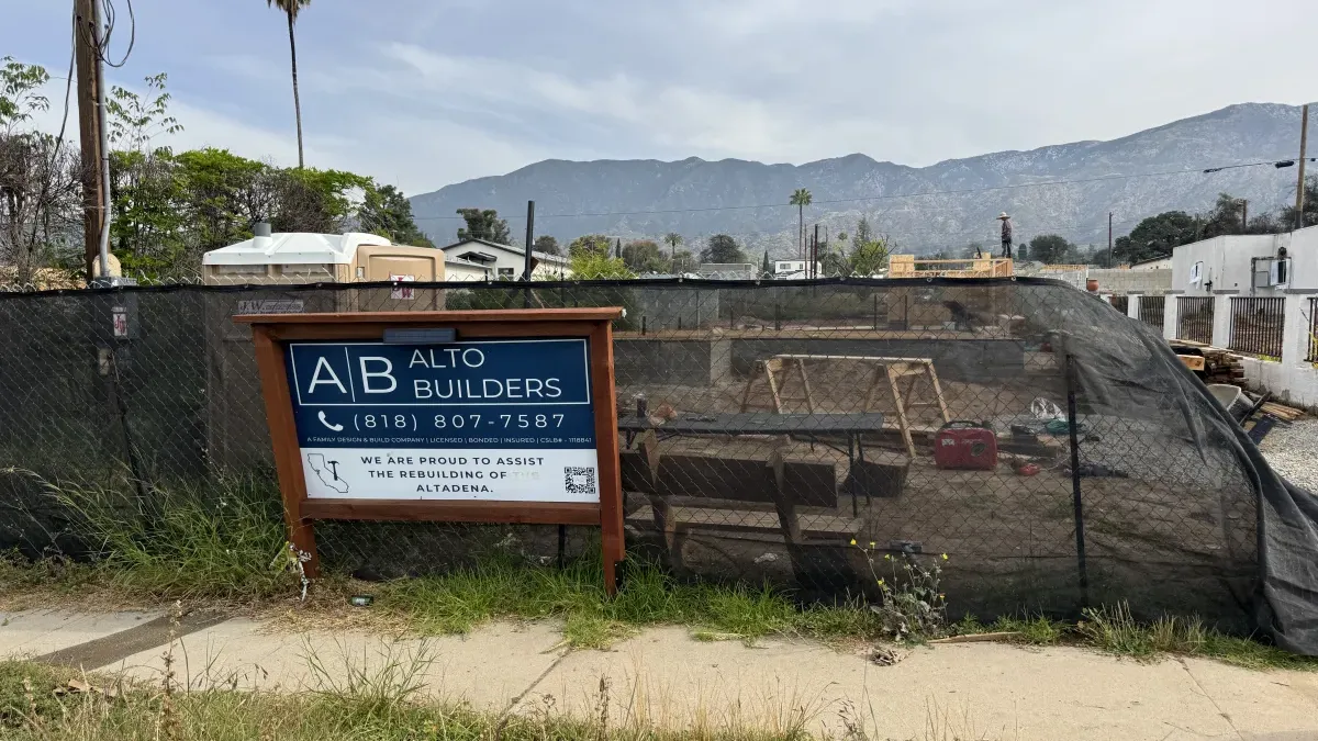 Pre-construction view of Altadena fire rebuild lot showing cleared site with construction sign and mountain views