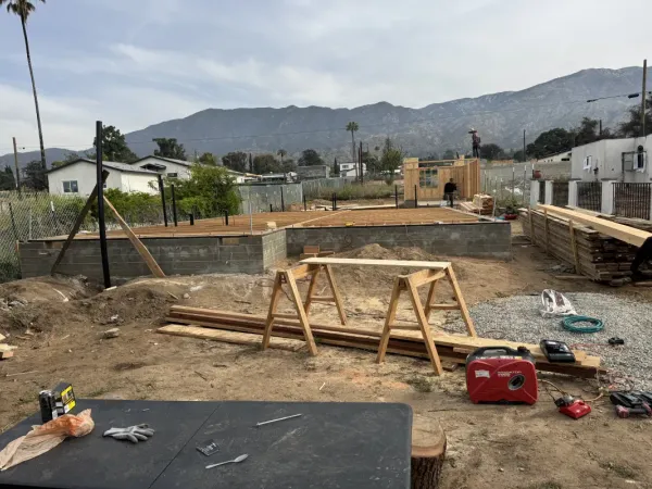 Concrete foundation and initial wall framing at Altadena fire rebuild construction site