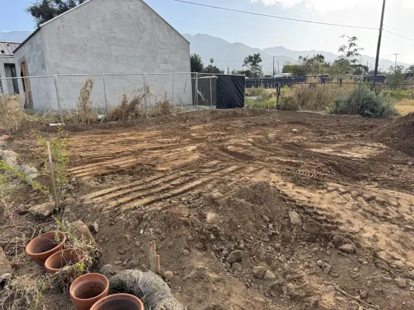 Site preparation with heavy machinery tire tracks and stucco building under construction