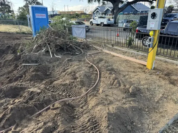 Altadena construction site with disturbed earth, portable toilet, and yellow power pole