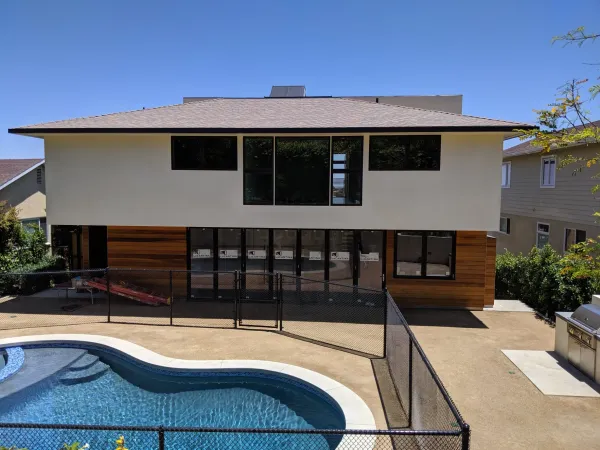 Modern home backyard with pool deck, retaining wall, and landscaping at Marquez Terrace
