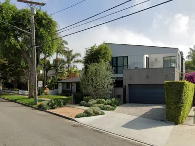 Modern two-story residence in Redondo Beach with metal siding, wood slat cladding, xeriscaping, and paver driveway
