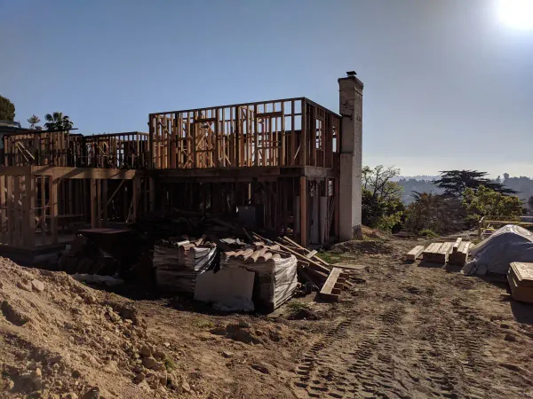 Construction site for a residential home on a steep hillside lot featuring grading and excavation for a future driveway and entrance